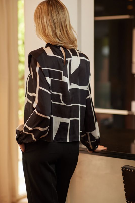 Style avant-gardiste avec la blouse Christy d'ANAE, ses motifs géométriques offrant une touche artistique à une tenue classique.