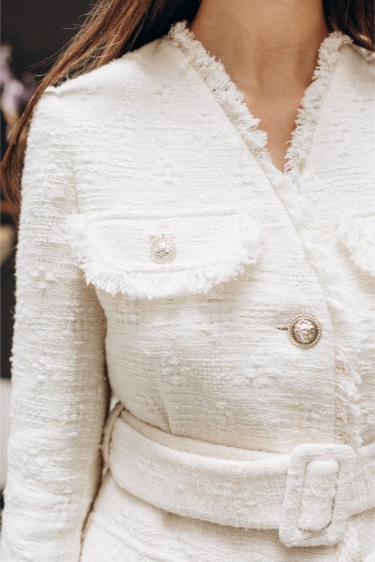 Vue rapprochée de la veste Rosy en tweed d'ANAE, mettant en lumière le tissu texturé et les détails des boutons.