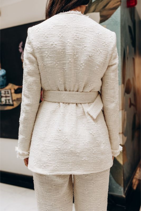 Profil de la veste en tweed Rosy d'ANAE, évoquant l'élégance et le style intemporel avec sa coupe croisée.
