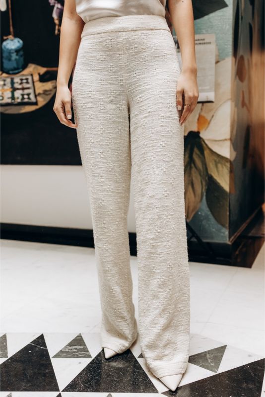 Gros plan sur un pantalon en tweed blanc ANAE, mettant en évidence la texture et la coupe soignée pour un style intemporel.