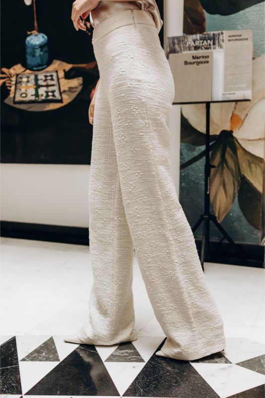 Gros plan sur un pantalon en tweed blanc ANAE, mettant en évidence la texture et la coupe soignée pour un style intemporel.