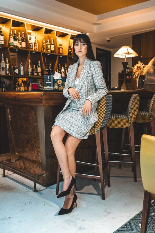 Femme en jupe en tweed ELAINE d'ANAE, style épuré et élégant, parfaite pour une ambiance de travail ou un événement semi-formel.