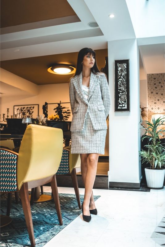 Femme en jupe en tweed ELAINE d'ANAE, style épuré et élégant, parfaite pour une ambiance de travail ou un événement semi-formel.