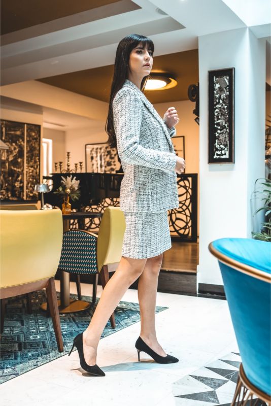 Femme en jupe en tweed ELAINE d'ANAE, style épuré et élégant, parfaite pour une ambiance de travail ou un événement semi-formel.