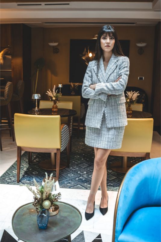Femme en jupe en tweed ELAINE d'ANAE, style épuré et élégant, parfaite pour une ambiance de travail ou un événement semi-formel.