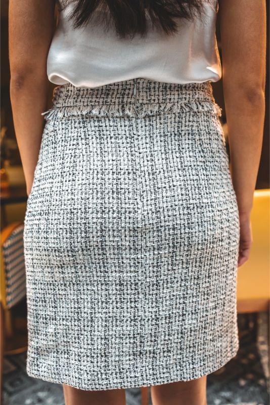 Détail de la jupe en tweed ELAINE d'ANAE, mettant en avant la texture et la bordure frangée pour un look moderne et chic.
