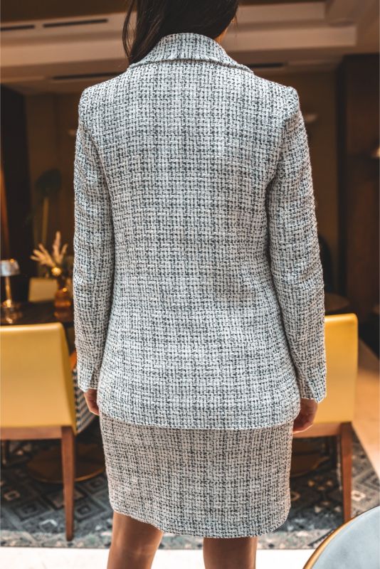 Femme en jupe en tweed ELAINE d'ANAE, style épuré et élégant, parfaite pour une ambiance de travail ou un événement semi-formel.