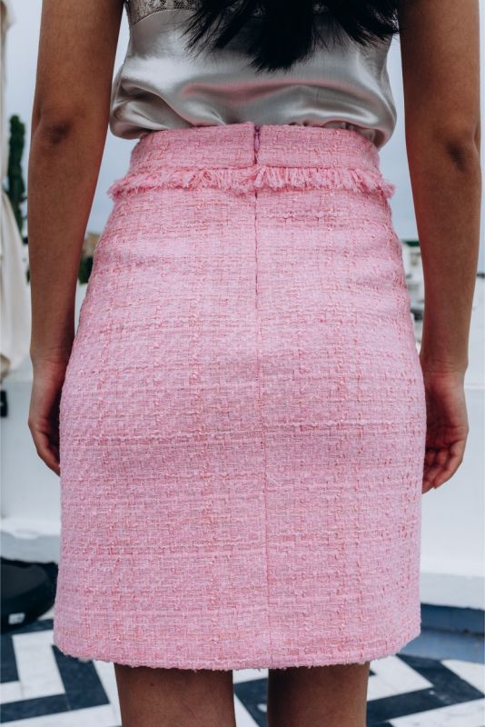 Gros plan sur la jupe en tweed rose ROSEMARY d'ANAE, texture détaillée et finition à bord brut pour un look branché.