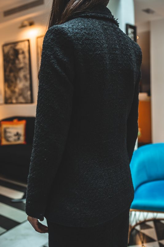 Gros plan sur la jupe ALISIA TWEED 24 d'ANAE, mettant en évidence la texture délicate du tweed et l'ourlet frangé tendance.