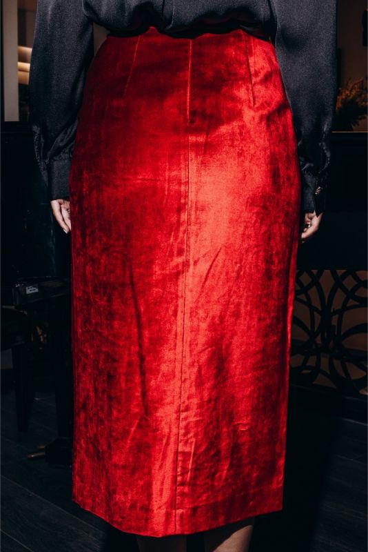 Détail de la jupe rouge satinée BOTERO ANAE, soulignant la taille cintrée et la texture lustrée du tissu.