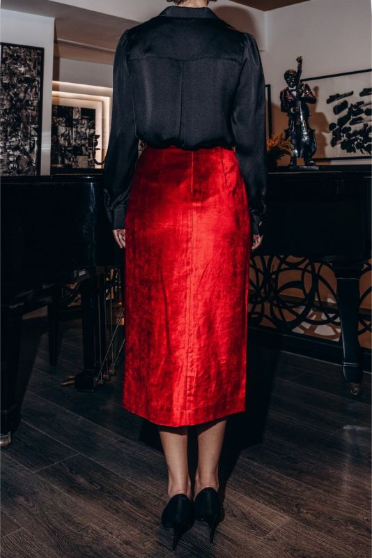 Détail de la jupe rouge satinée BOTERO ANAE, soulignant la taille cintrée et la texture lustrée du tissu.