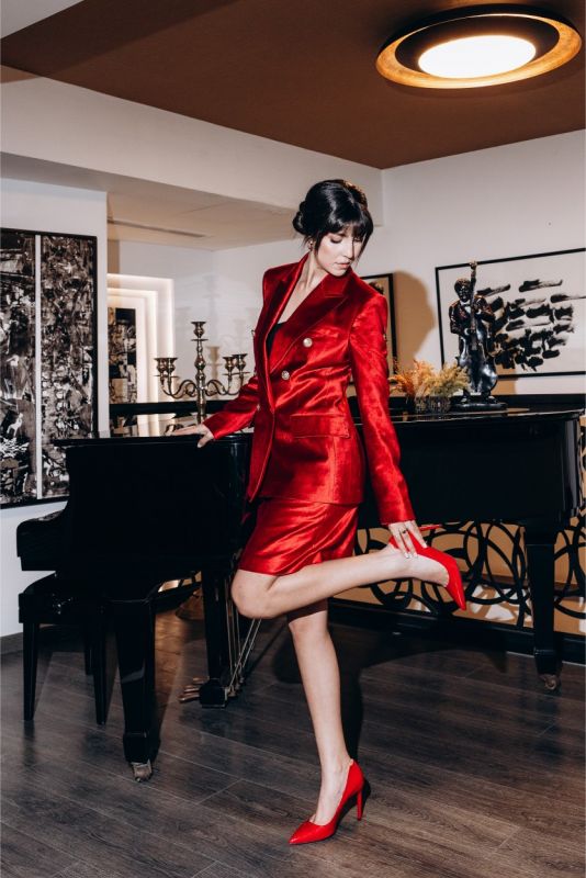Femme dynamique en jupe ROUGE Valentine 24 d'ANAE, complétée par des escarpins assortis, pour un look audacieux et chic.