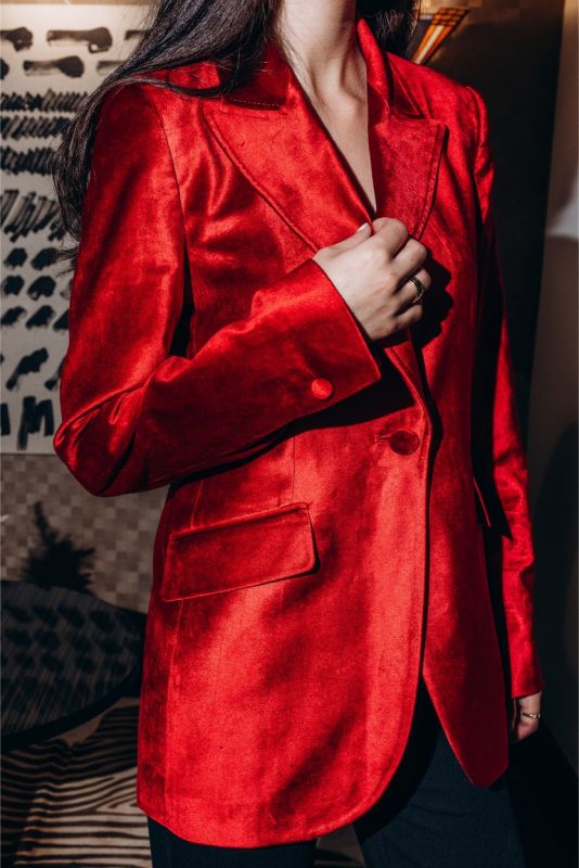 Vue rapprochée de la veste en velours rouge INGRID d'ANAE, montrant la texture riche et les détails de couture précis.