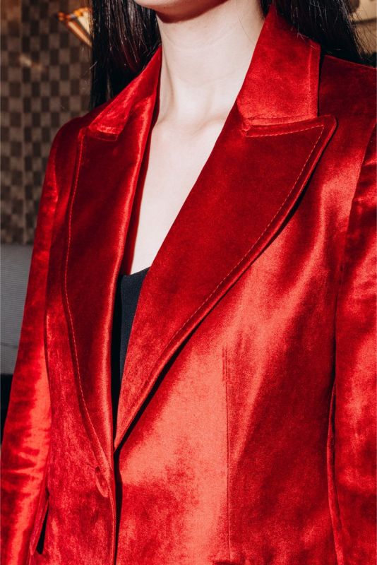 Col et revers de la veste en velours rouge INGRID d'ANAE, capture détaillée soulignant la finition haut de gamme.