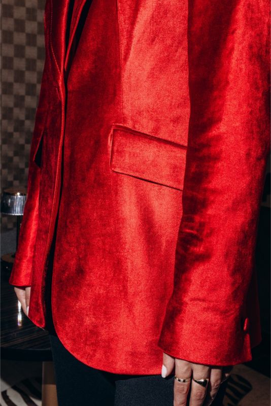 Vue rapprochée de la veste en velours rouge INGRID d'ANAE, montrant la texture riche et les détails de couture précis.