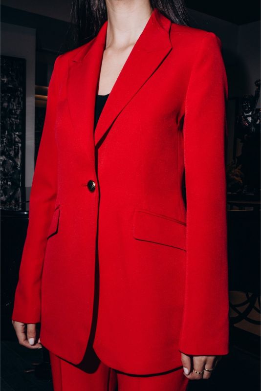 Veste rouge structurée ANAE avec bouton décoratif noir, mettant en avant une sophistication intemporelle.