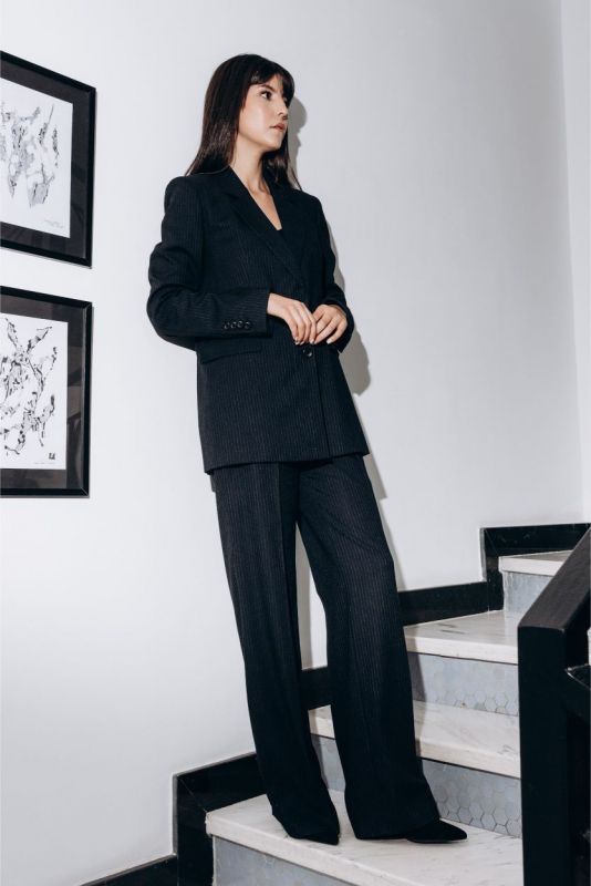 Femme en blazer et pantalon Jeff de la collection Tweed 24 d'ANAE, élégance contemporaine.