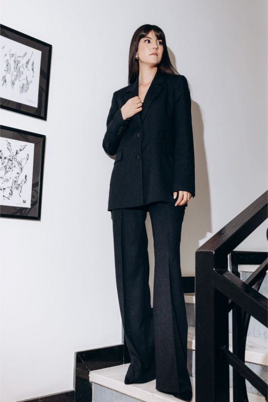 Femme en blazer et pantalon Jeff de la collection Tweed 24 d'ANAE, élégance contemporaine.