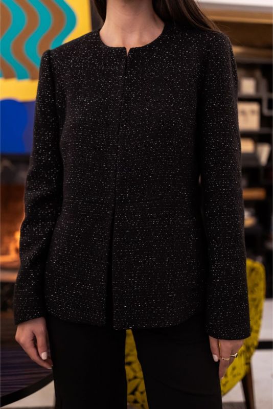 Vue arrière d'une femme portant la veste Margaret noire à détails scintillants, collection Tweed 23 d'ANAE.