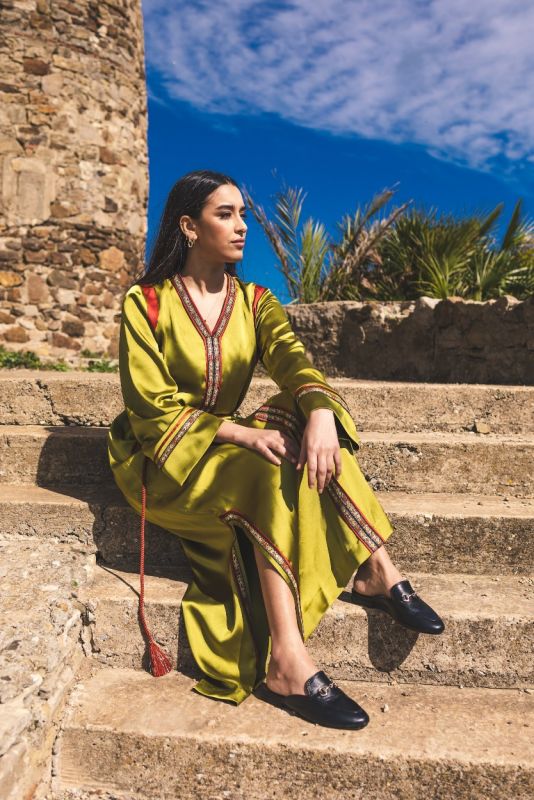 Caftan FAIROUZ d'ANAE couleur vert olive avec détails rouge et doré, évoquant l'élégance décontractée.