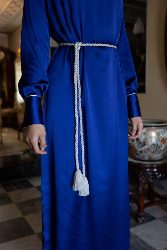 Détail du caftan SAKINA d'ANAE en bleu roi, manches avec revers et ceinture à pompons blancs.