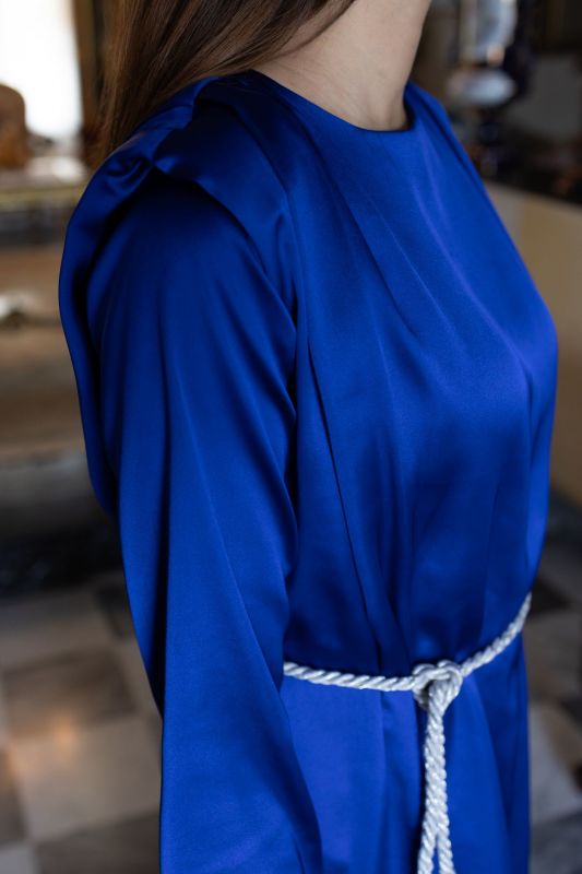Détail du caftan SAKINA d'ANAE en bleu roi, manches avec revers et ceinture à pompons blancs.