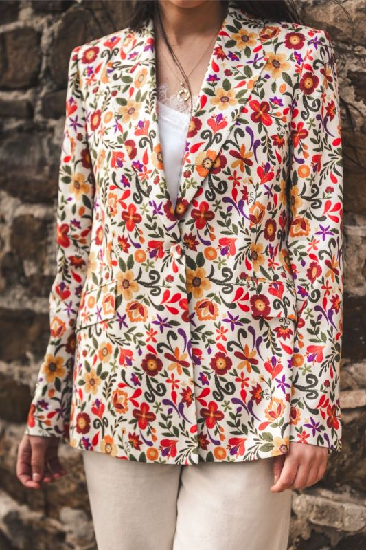 Détail de la veste JEANNA d'ANAE, mettant en évidence la texture riche et les motifs fleuris.