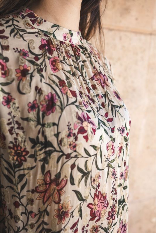 Vue rapprochée de la blouse Wallin d'ANAE avec col montant et imprimé floral délicat.
