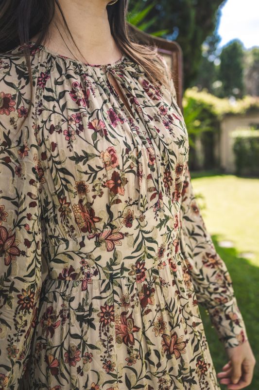 Détail du tissu fleuri de la robe PALM d'ANAE, mettant en évidence les plis délicats et le col noué.