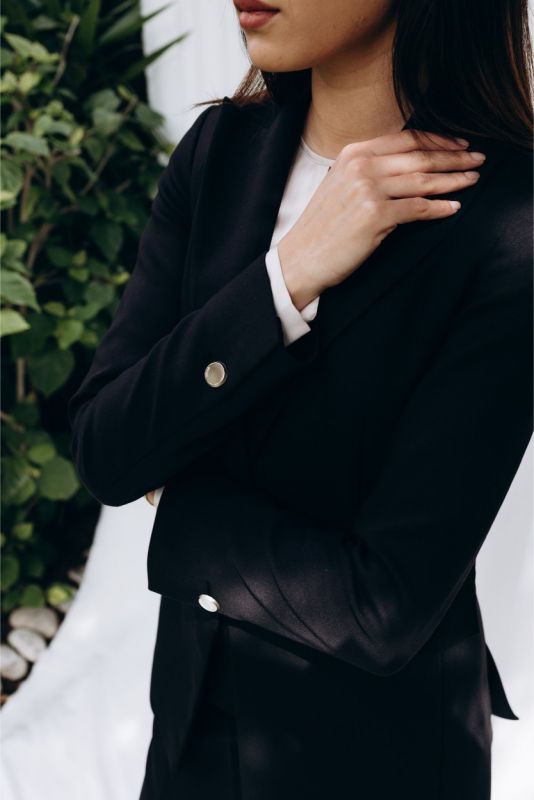 Détail de la veste 'Lorena' ANAE : bouton unique doré, équilibre parfait entre minimalisme et sophistication.