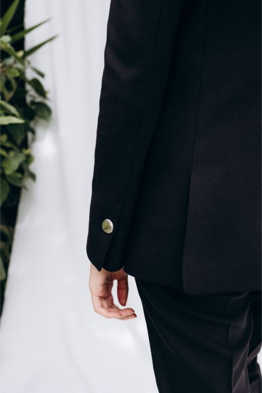 Détail de la veste 'Lorena' ANAE : bouton unique doré, équilibre parfait entre minimalisme et sophistication.