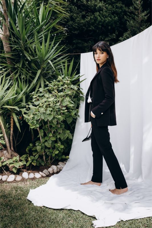Femme chic en veste noire 'Lorena' d'ANAE, alliance de confort et d'élégance naturelle, prête pour toute occasion.