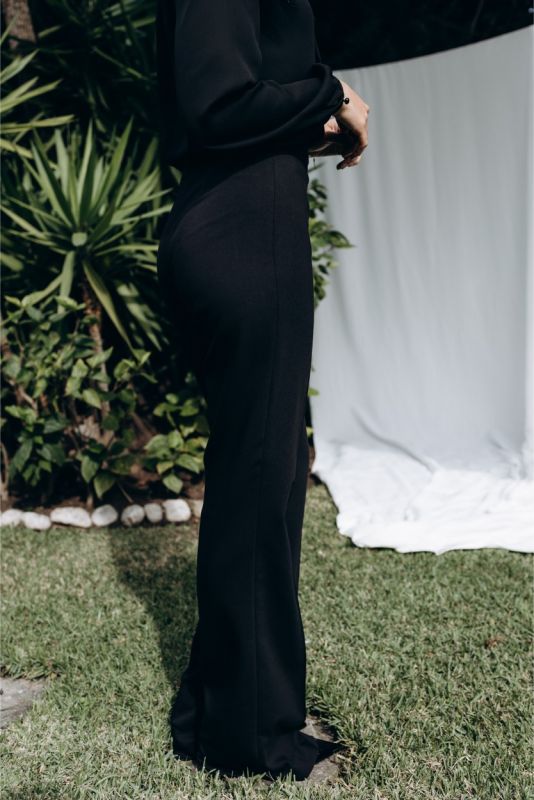 Vue de trois quarts du pantalon évasé ANAE, mettant en valeur la coupe fluide et le style sophistiqué.