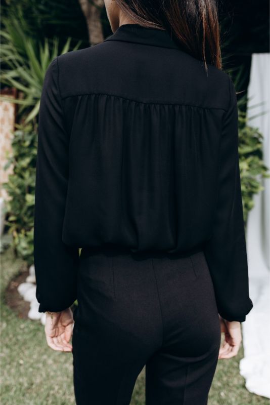 Détail de la blouse 'Belkis' d'ANAE, avec son nœud et manchettes boutonnées, épitomisant une élégance discrète.