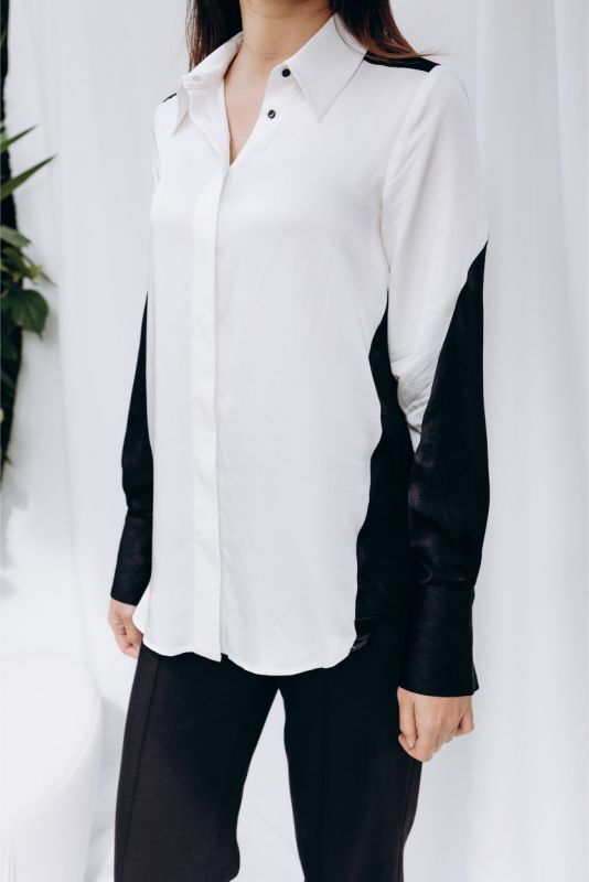 Vue de profil de la chemise 'Celia' d'ANAE, manches noires élégantes, ajoutant une touche de mystère à la silhouette féminine.