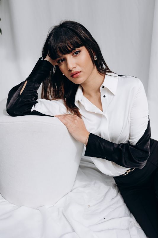 Vue de profil de la chemise 'Celia' d'ANAE, manches noires élégantes, ajoutant une touche de mystère à la silhouette féminine.