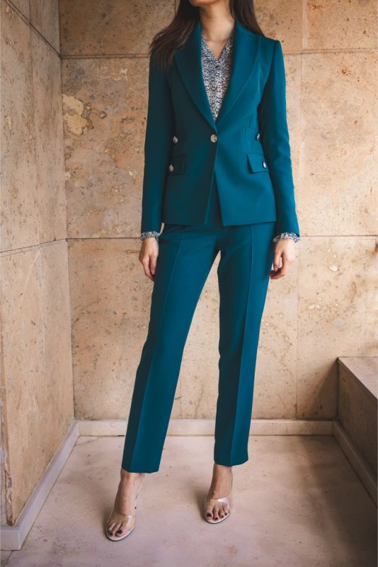 Tenue de tailleur ANAE bleu émeraude avec blazer structuré et pantalon fuselé, incarnant l'élégance moderne.
