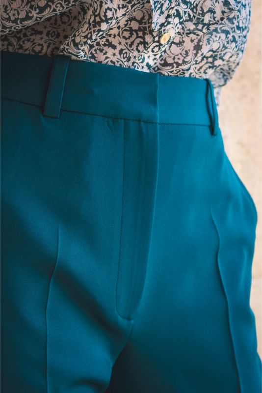Détail de pantalon tailleur ANAE bleu émeraude, mettant en avant la qualité du tissu et la précision de la coupe.