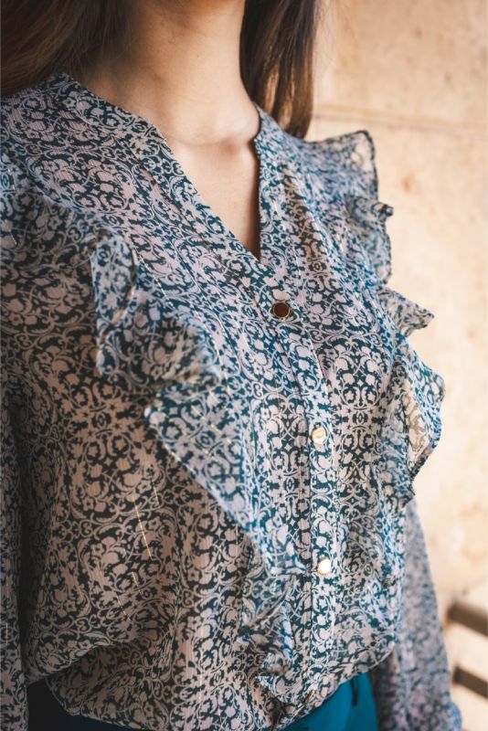 Chemisier ANAE aux motifs cachemire bleus et gris avec volants délicats et boutons dorés, reflétant un charme vintage.