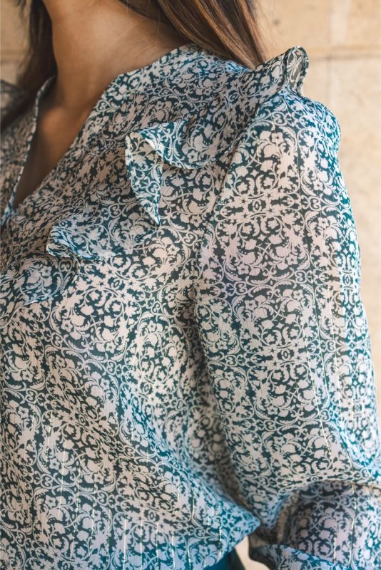 Vue rapprochée sur un chemisier imprimé paisley ANAE, mettant en valeur les détails raffinés et les boutons contrastants.