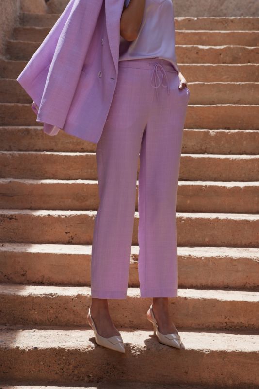 Gros plan sur le pantalon Teresa lilas, montrant la ceinture à nouer et le haut en soie.