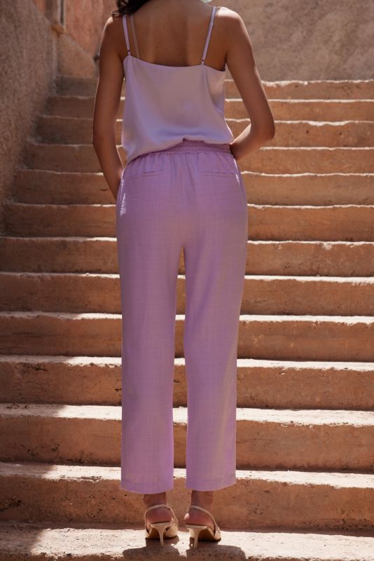 Vue de face du pantalon Teresa lilas, associé à un haut en soie et des talons beiges.